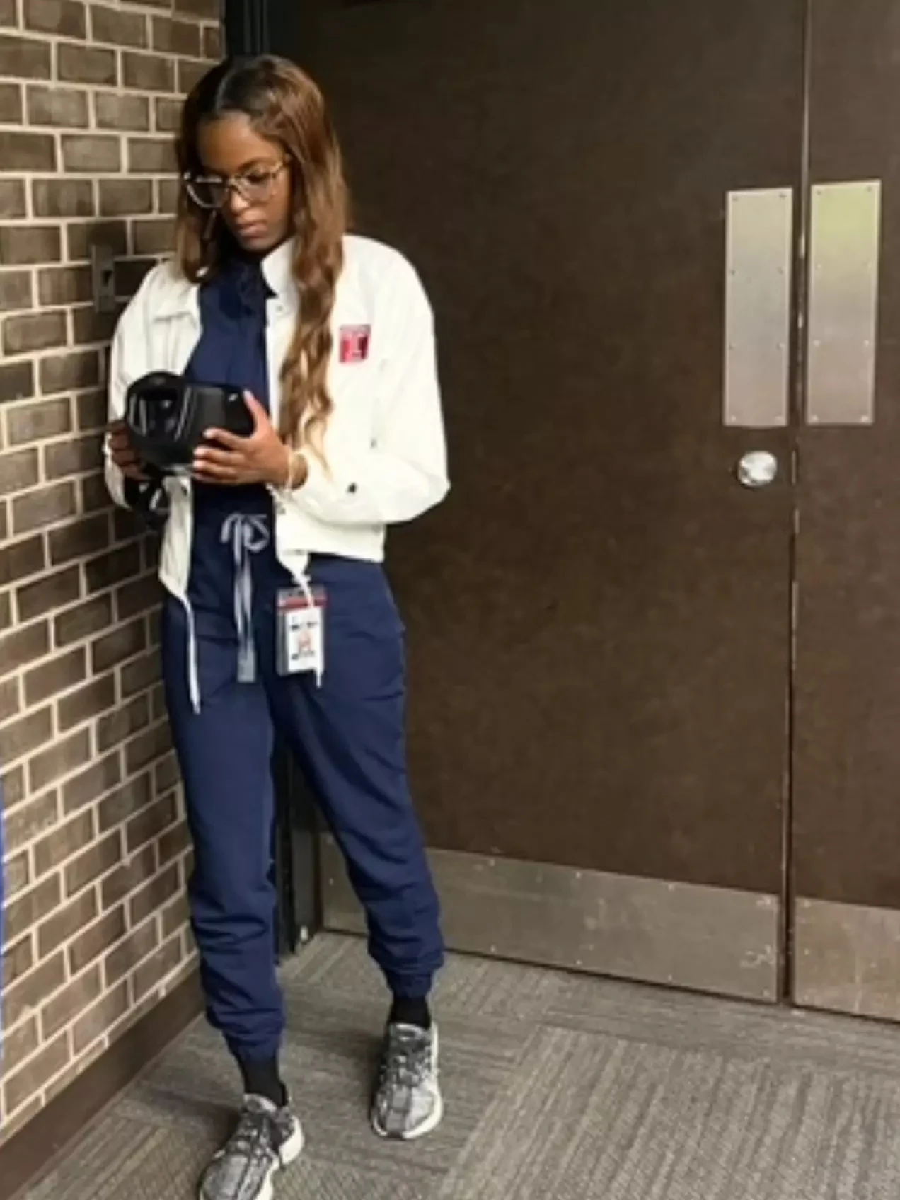 Tamia Law looks at a Spot vision screener in a corridor